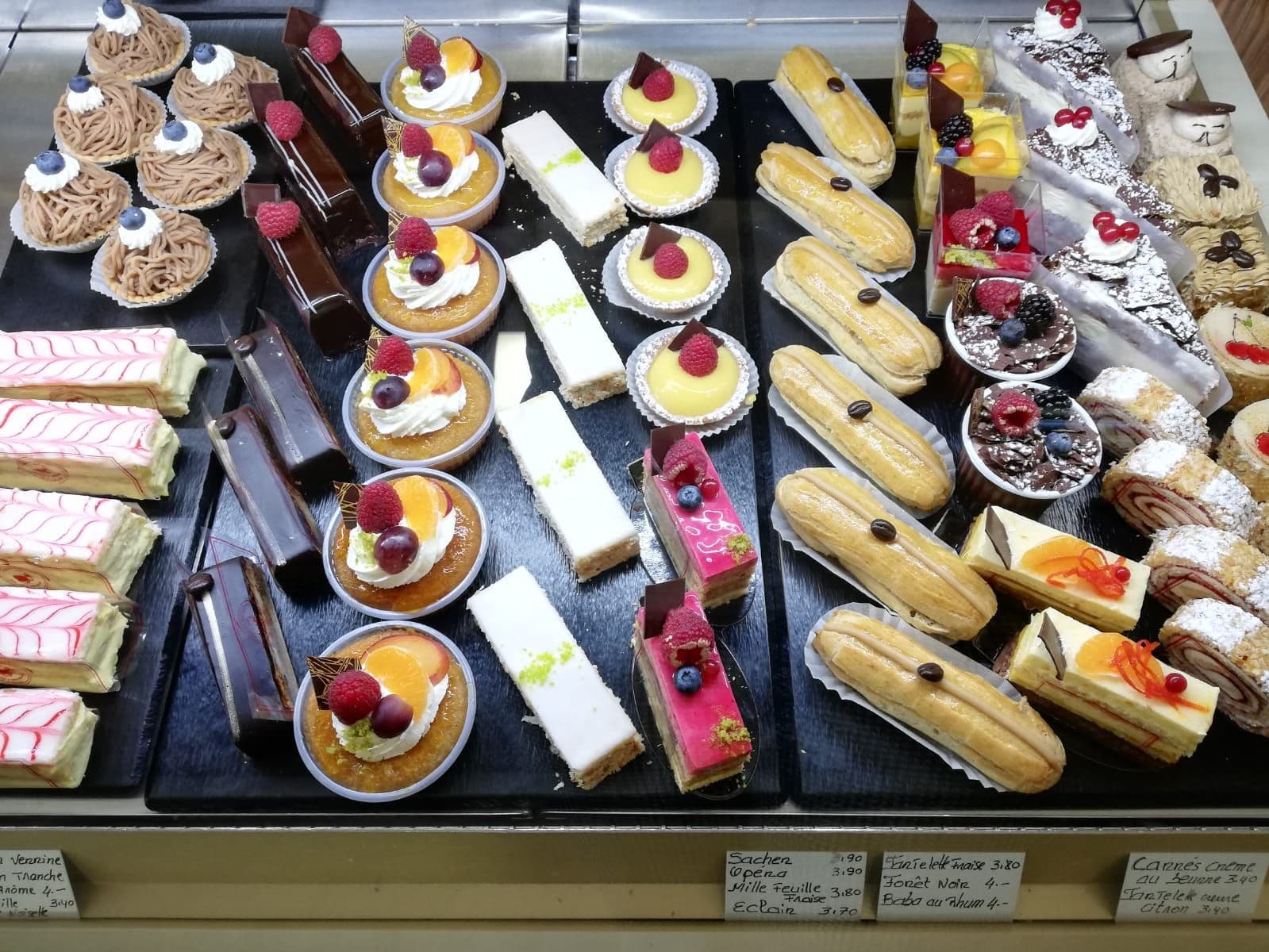 Éclairs, tartelettes, mille-feuilles et entremets sur les plateaux d'ardoise de la Confiserie Baechler.