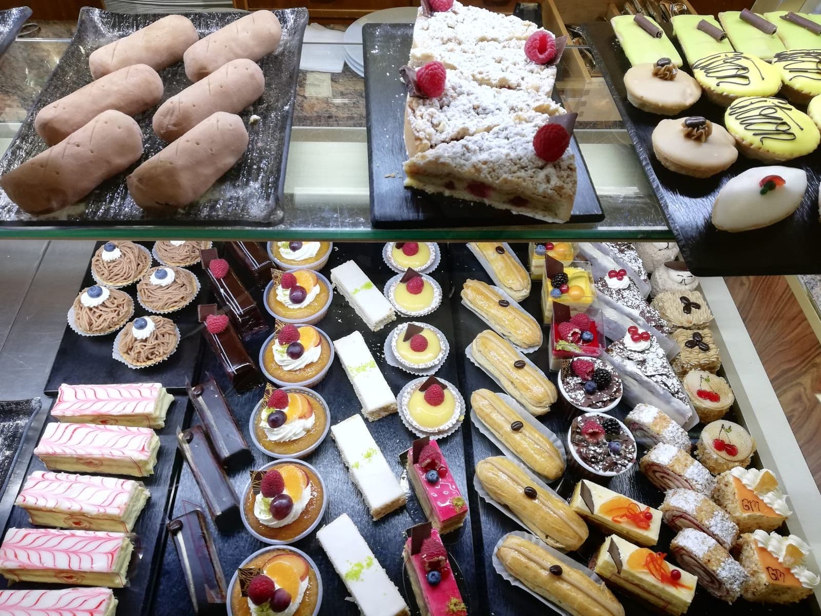 Pains, gâteau aux fruits et pâtisseries du jour dans la vitrine de la Confiserie Baechler.